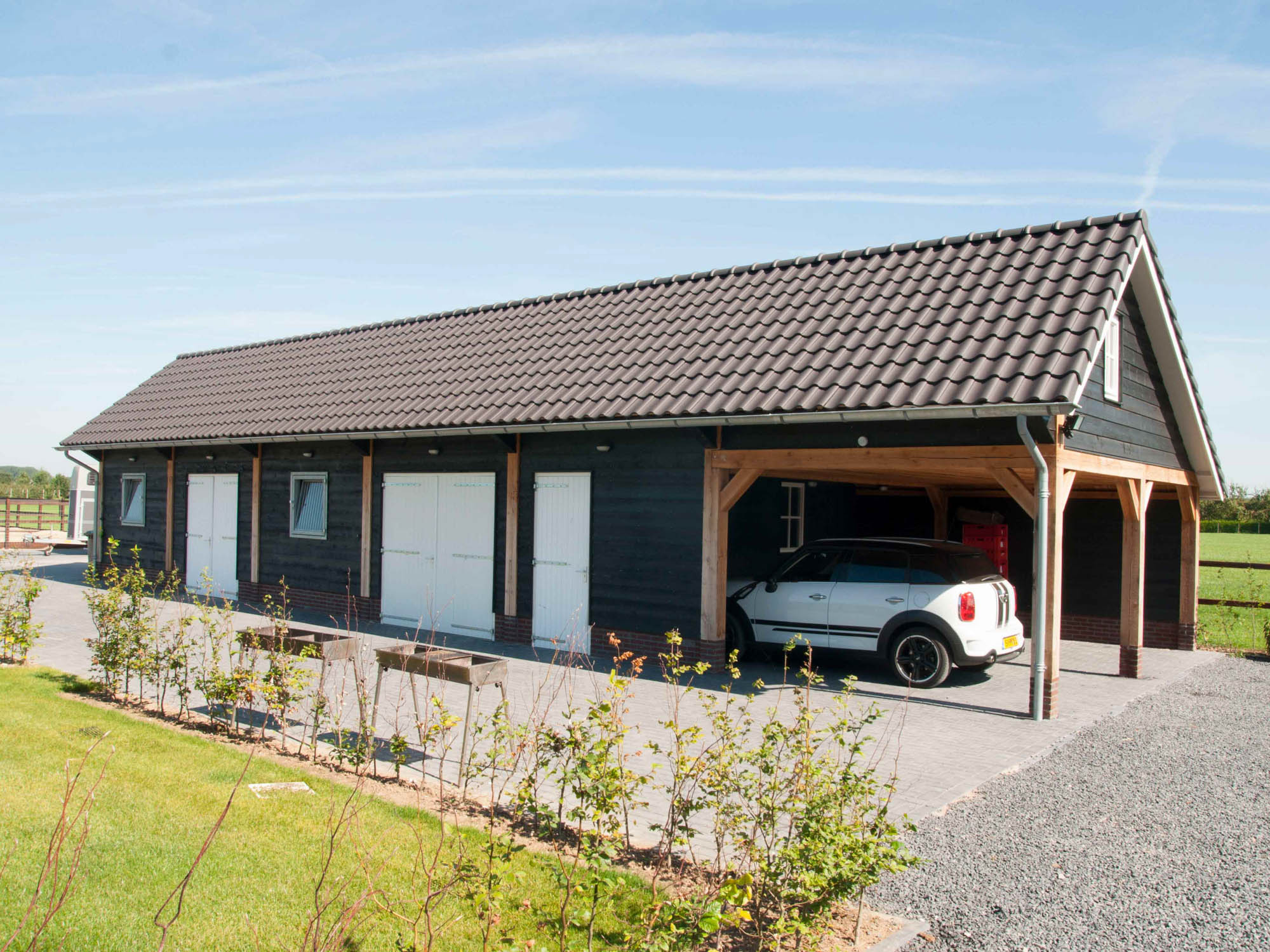 Grote schuur met garagedeuren en carport • schuur overkapping