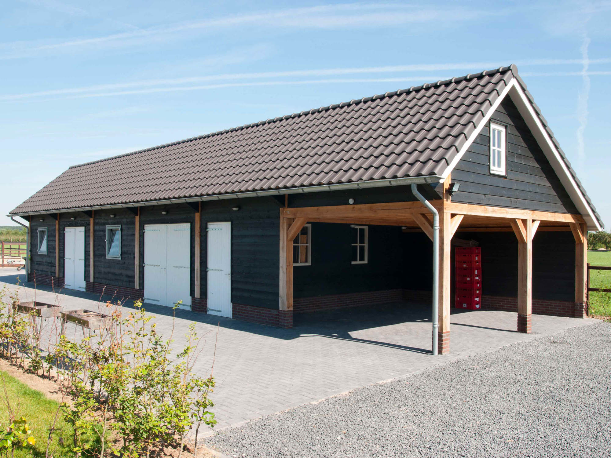 Grote schuur met garagedeuren en carport • schuur overkapping