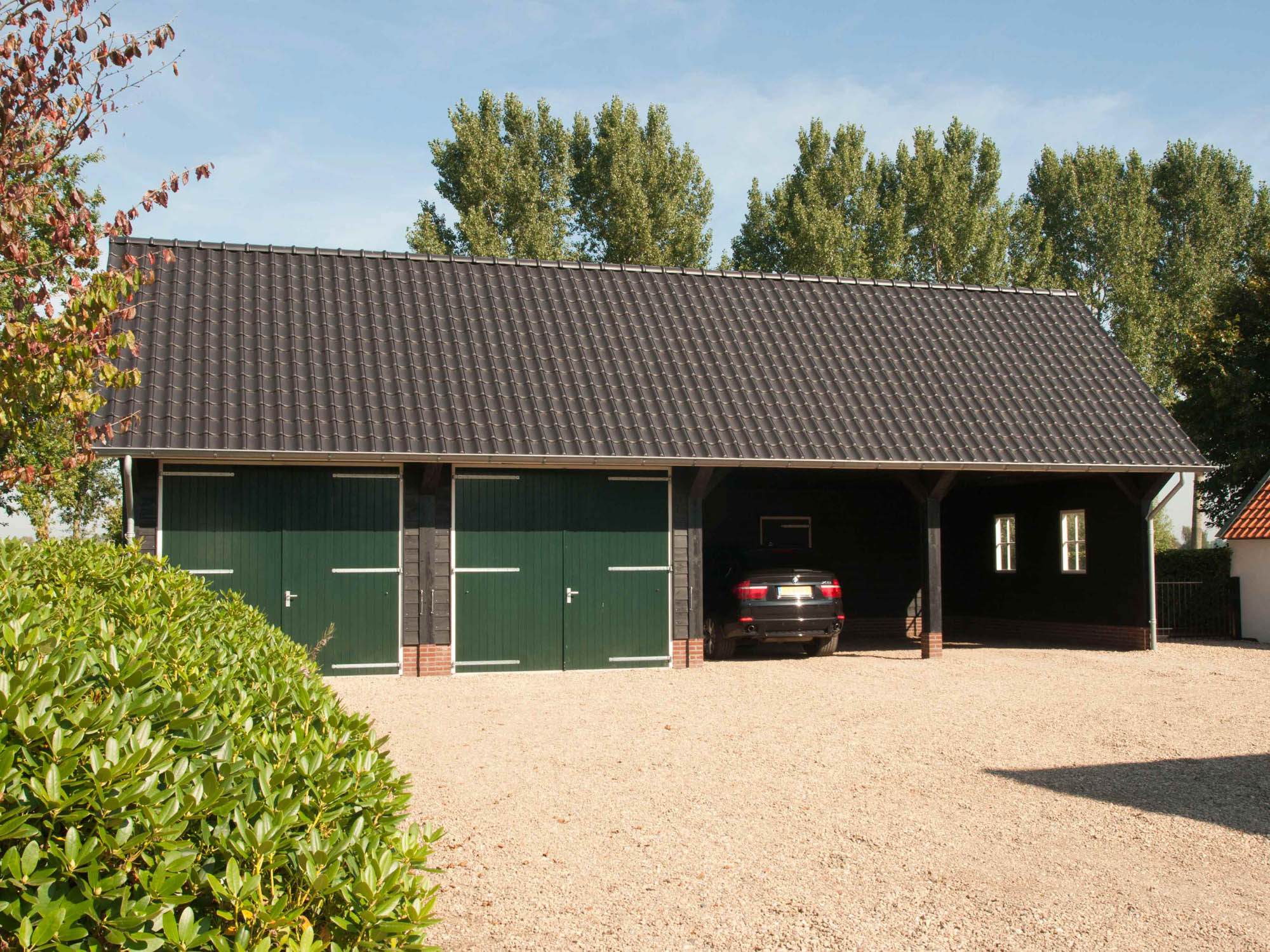 telegram uitsterven Barmhartig Grote houten zwarte schuur met dubbele deuren en carports • Houten schuur  met overkapping