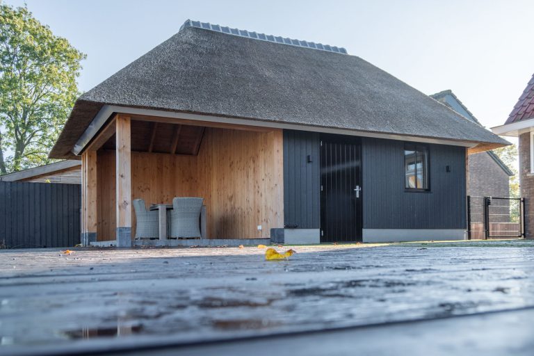 Tuinhuis met rieten dak als perfecte loungeplek